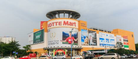 A shopping mall with a prominent Lotte Mart sign and advertisements for LG OLED TV and cinema.