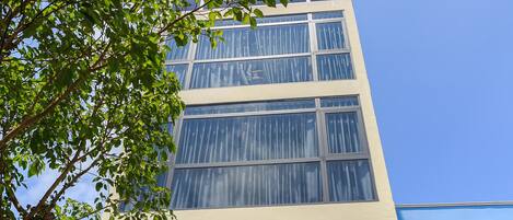 A building with a sign for 'Marine Hotel Apartment' and a contact number.