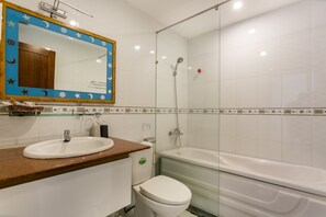 Un baño con lavamanos, inodoro y bañera.