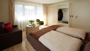 Une chambre d’hôtel moderne équipée de deux lits, d’un bureau, d’une chaise et d’une armoire.