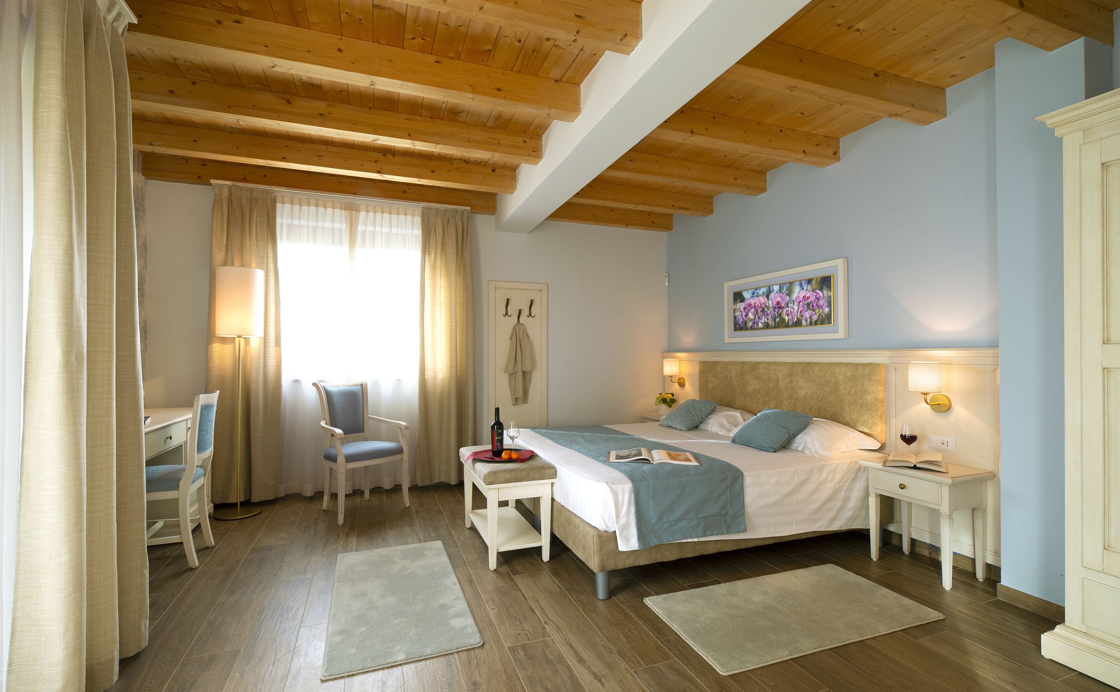 Ein Schlafzimmer mit Bett, Nachttischen, einem Schreibtisch und einem Sessel.