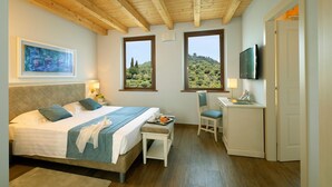 A bedroom with a bed, a desk, a chair, a TV, and a painting. - BORGO ROMANTICO GREEN RELAIS (Cavaion Veronese)