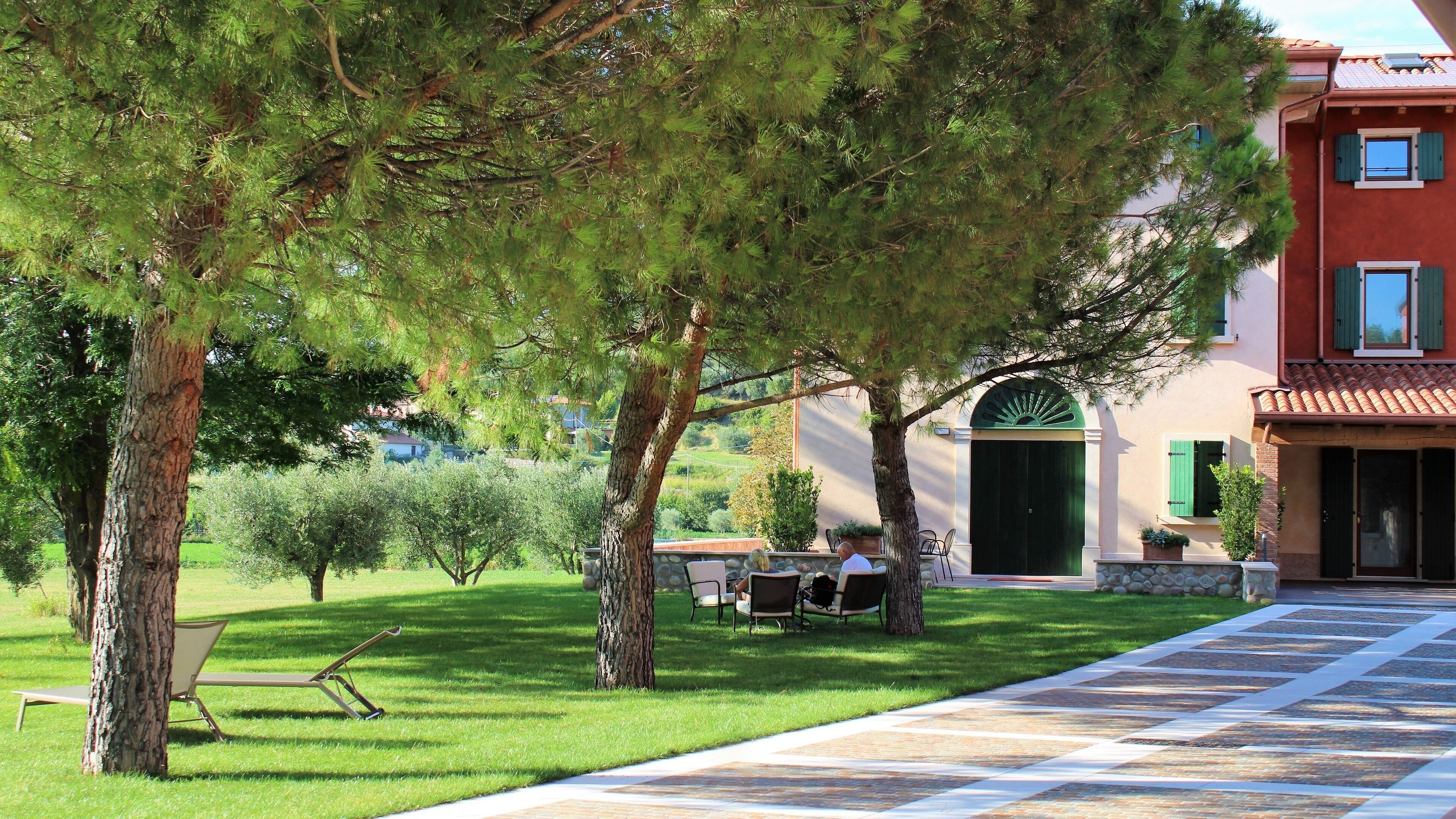 A villa with a paved pathway, outdoor seating, and a green door.