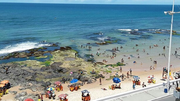 Ein Strand mit Felsen und klarem, blauem Wasser.