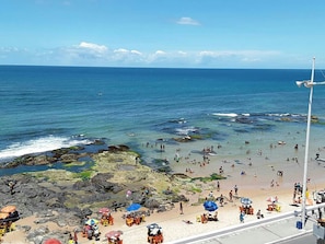 A beach with rocky areas and clear blue water. - Pousada Mar Aberto (Salvador)