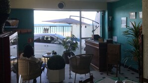 Ein Zimmer mit Meerblick, eine Essecke mit Stühlen und einem Tisch sowie eine Rezeption.
