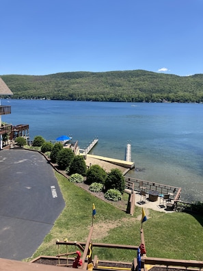 A lakeside view with a dock, a parking area marked "No Parking," and a playground with a slide. - Park Lane Motel (Lake George)