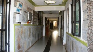 A hallway with stone walls, a black stripe on the floor, and a green accent wall. - Amboseli Getaway Hotel (Kimana)