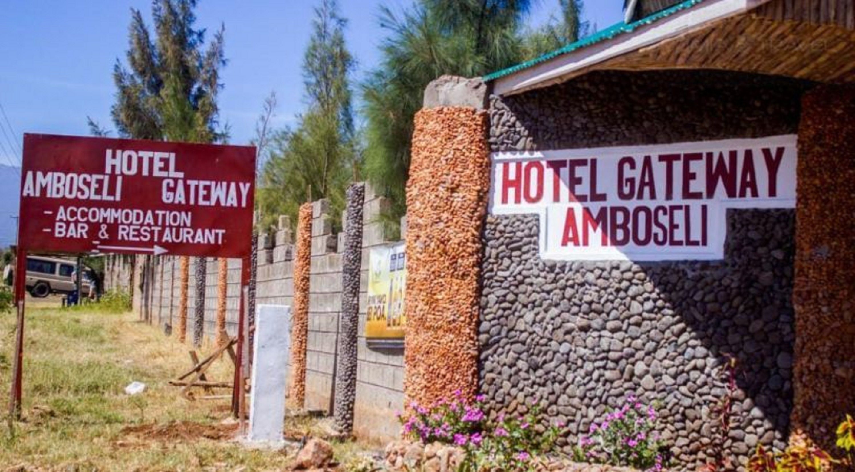 A hotel gateway with signs indicating accommodation, bar, and restaurant services.