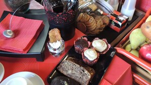 Una mesa de bufé con diversos alimentos, como galletas, cupcakes y una hogaza de pan.