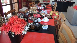 Un comedor con una mesa preparada para el desayuno, que incluye diversos alimentos y utensilios.