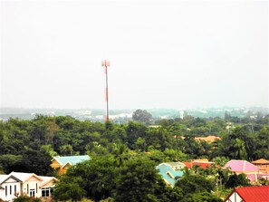 A residential area with houses surrounded by greenery, a prominent communication tower, and a distant water tower. - Spacious Studio View Talay 2 (Pattaya)