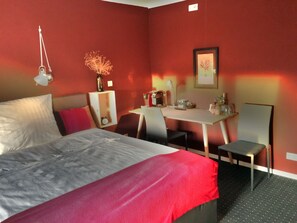 A hotel room with a bed, a desk, and a chair. - Aparthotel Flughafen Leipzig (Schkeuditz)