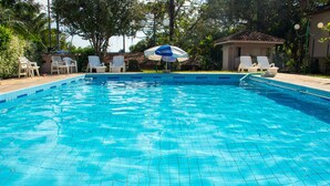 A clear blue swimming pool with tiled flooring, surrounded by white lounge chairs and a small pavilion with a tiled roof. - Hotel Caldas da Imperatriz (Santo Amaro da Imperatriz)