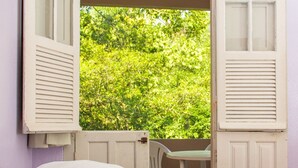 A bedroom with two beds, a window with shutters, and a view of greenery outside. - Hotel Caldas da Imperatriz (Santo Amaro da Imperatriz)