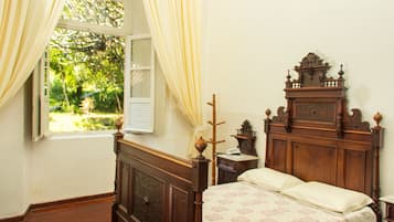 Un dormitorio con cama de madera, una mesita de noche y una ventana con cortinas.