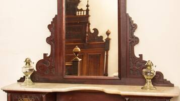 A wooden vanity with a mirror, a sink, and two brass fixtures.