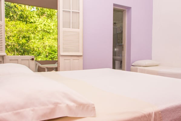 A bedroom with a bed, a small table, and a shower area. - Hotel Caldas da Imperatriz (Santo Amaro da Imperatriz)