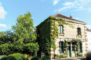 Een historisch gebouw met muurranken, een traditioneel pannendak en een groene deur.