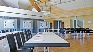 A conference room with a long table, black chairs, and whiteboards with text. - Ökölogisches Bildungszentrum Kultiviert (Wildpoldsried)