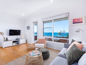 Relax in a spacious living room with a flat-screen TV, comfortable seating area, and ocean views.