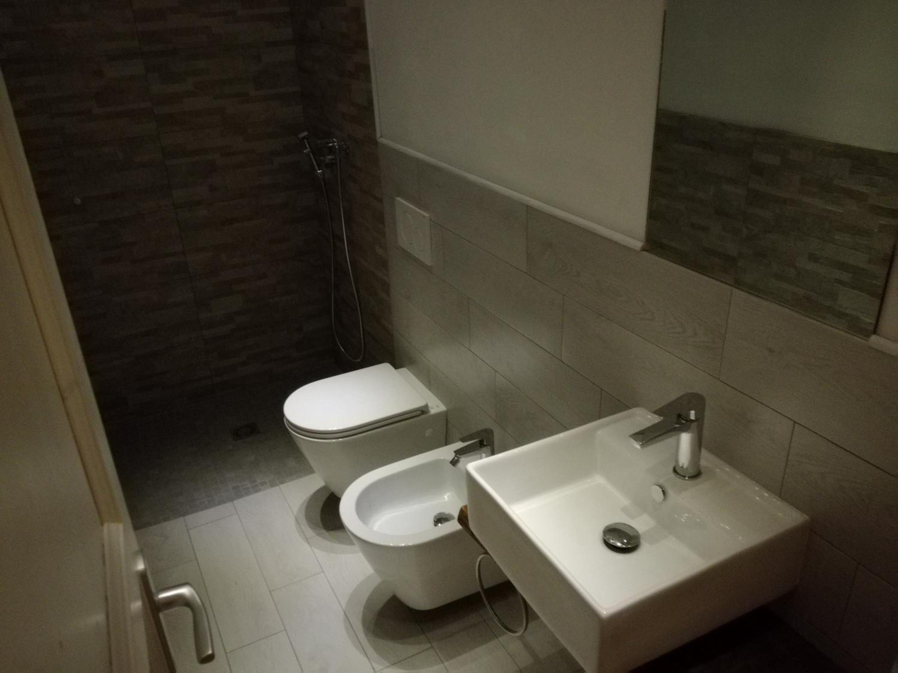 A bathroom with a toilet, bidet, and sink.