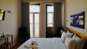 A hotel room with a bed, two chairs, a desk, and a large window with curtains. - Ó poboa guesthouse (Povoa De Varzim)