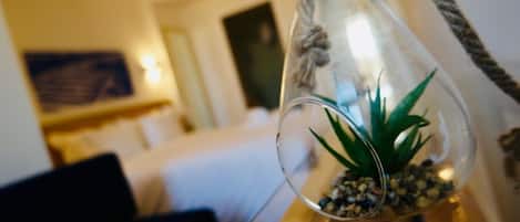 A clear glass terrarium with a succulent plant and pebbles on a wooden surface.