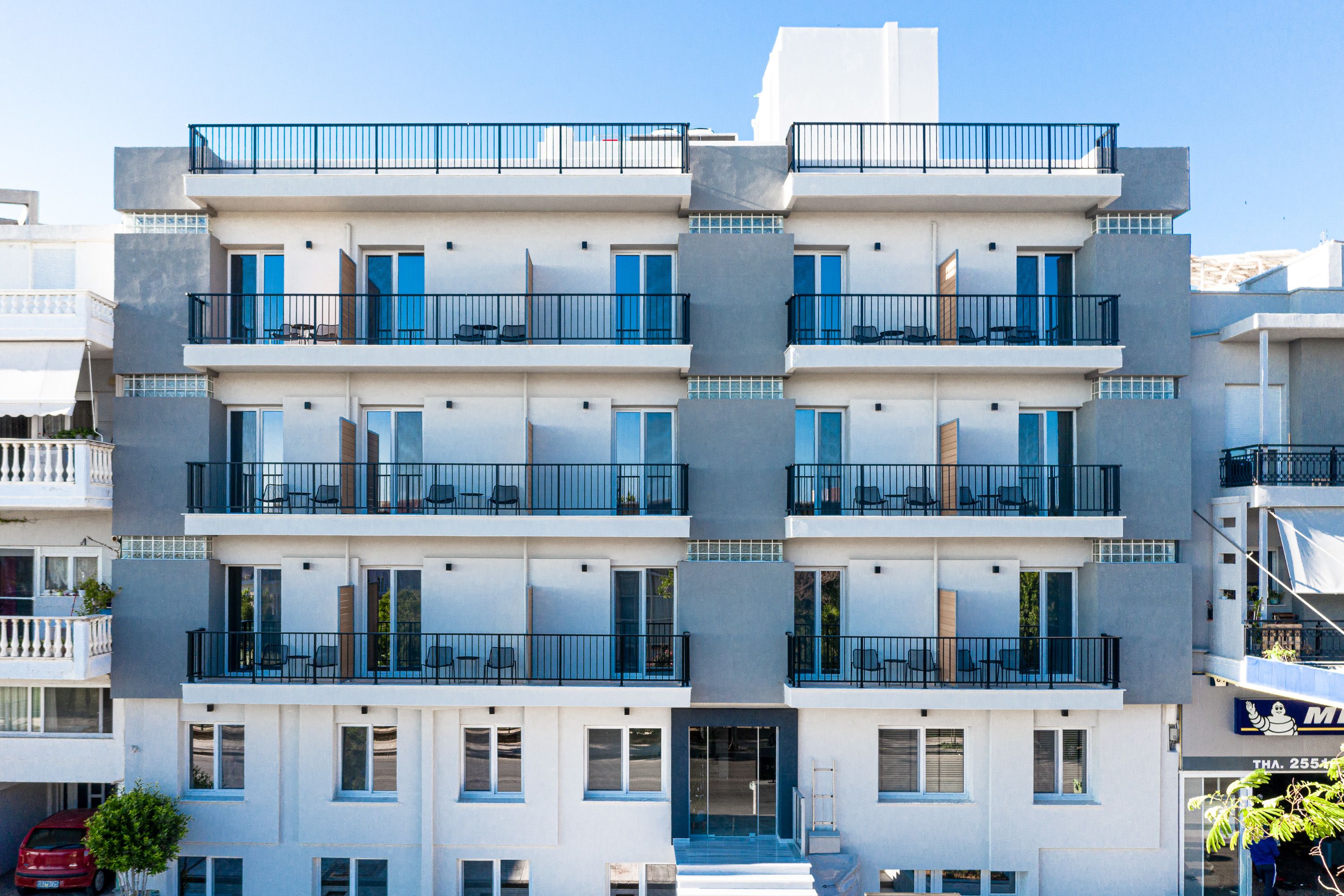 Um hotel moderno de vários andares com varandas, grandes janelas e fachada cuidada.