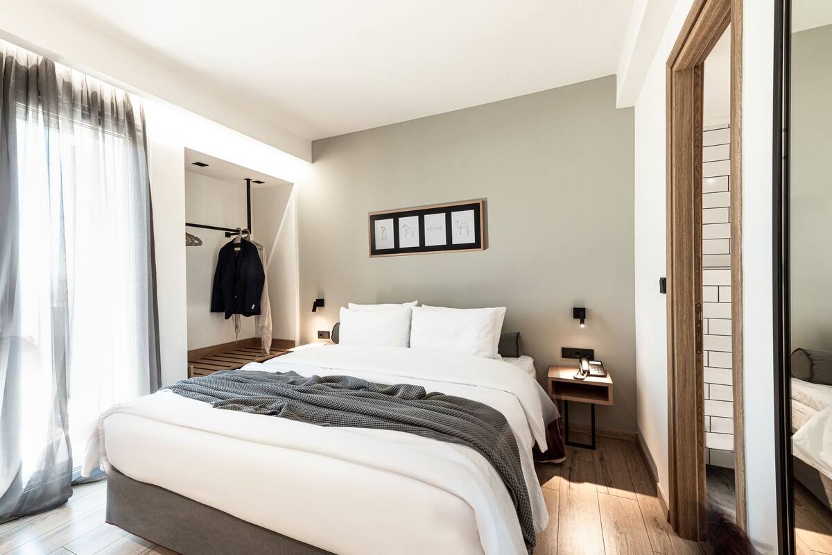 Une chambre d’hôtel moderne avec un grand lit, un bureau et une armoire.