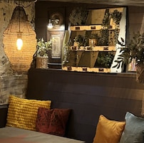 Un rincón acogedor con un revestimiento texturizado, una lámpara colgante y una pared decorativa con plantas.