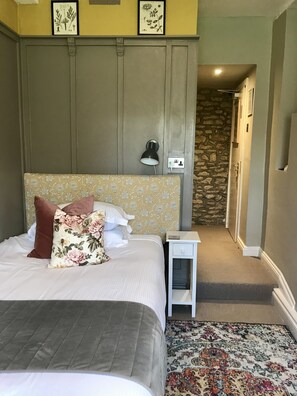 Une chambre à coucher avec un lit, une table de chevet, une lampe et un tapis.