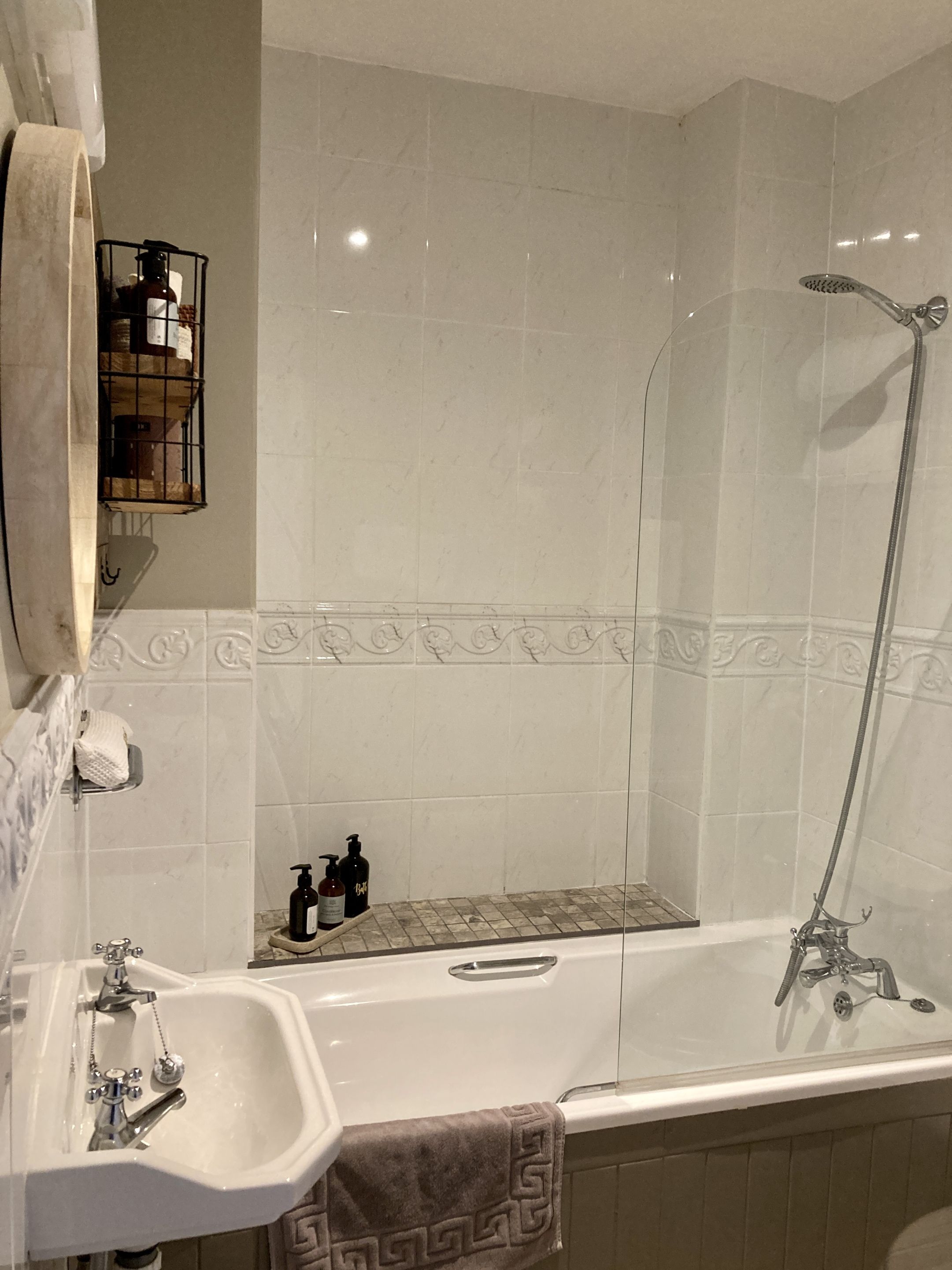 A bathroom with a bathtub, a sink, a mirror, and a shower.