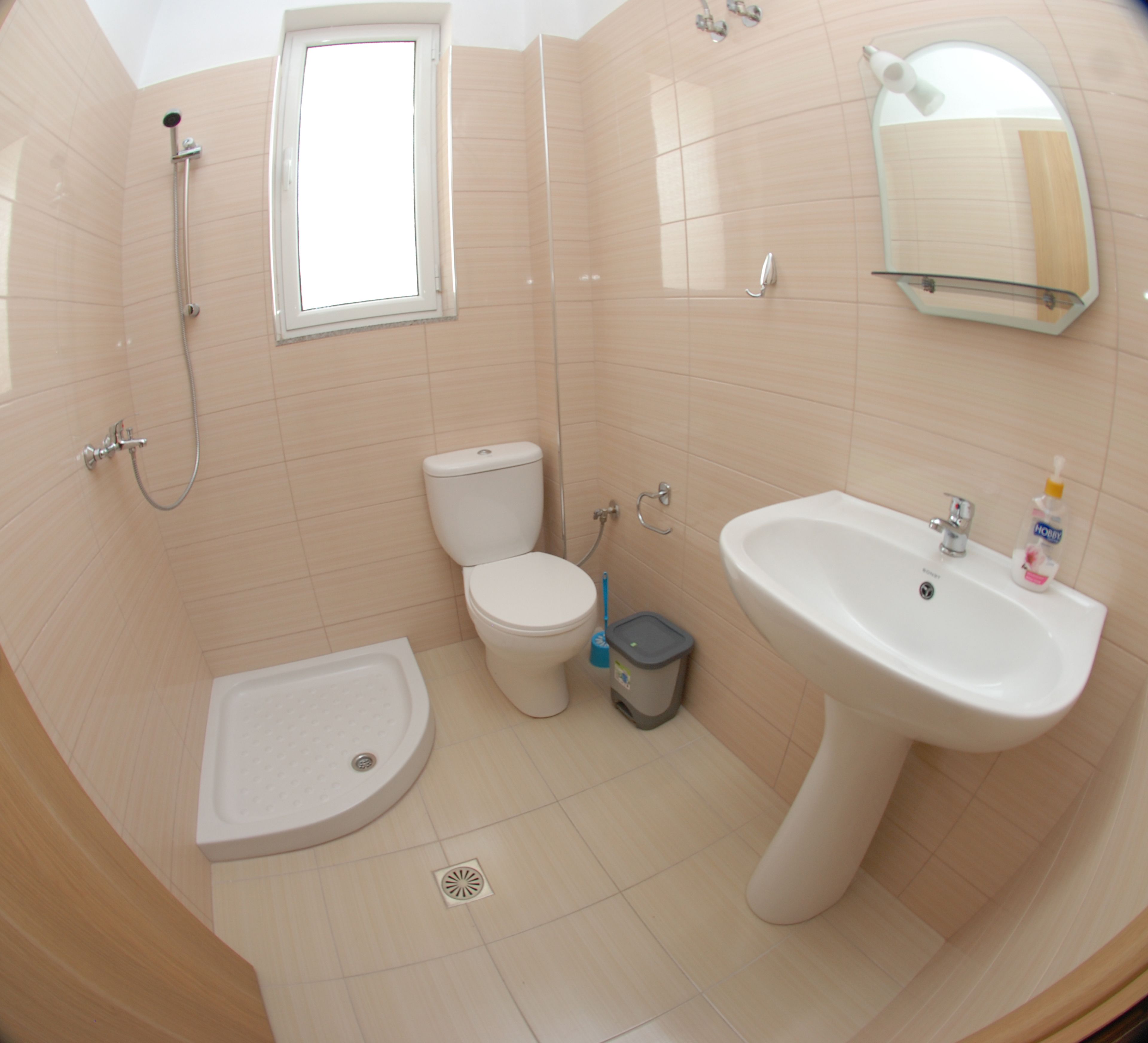 Un bagno con doccia, WC, bidet e lavandino.