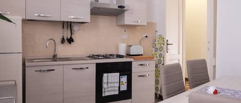 Apartamento, 2 quartos | Cozinha privada | Geladeira grande, cooktop, talheres/pratos/utensílios de cozinha