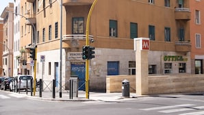 A multi-story building with balconies, a visible storefront, and a street intersection. - Roma - Via la Spezia 70 (Rome)