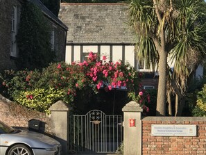 A gated entrance with a sign for Stephen Knightley & Associates, a brick wall, and a car parked in front.