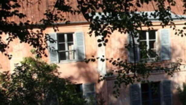 A row of traditional European-style buildings with uniform architecture, featuring shuttered windows and a consistent facade. - Chez Jules et Léonie (Valmondois)