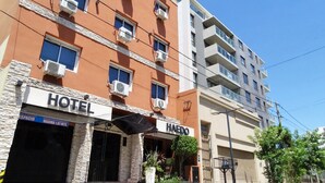 A hotel with multiple air conditioning units, a sign for 'HAEDO', and a clear blue sky. - Hotel Haedo (Haedo)