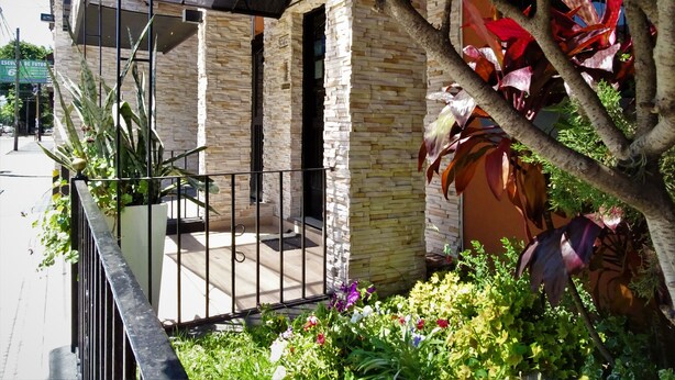 A building with a stone facade, a gated entrance, and a small porch area. - Hotel Haedo (Haedo)