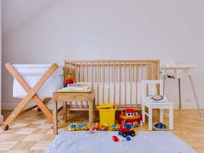 Cozy space for kids, featuring a crib, table, and toys.