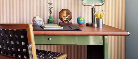 A desk with a globe, a trophy, and a lamp.