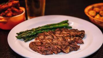 A plate with steak and asparagus on a table.