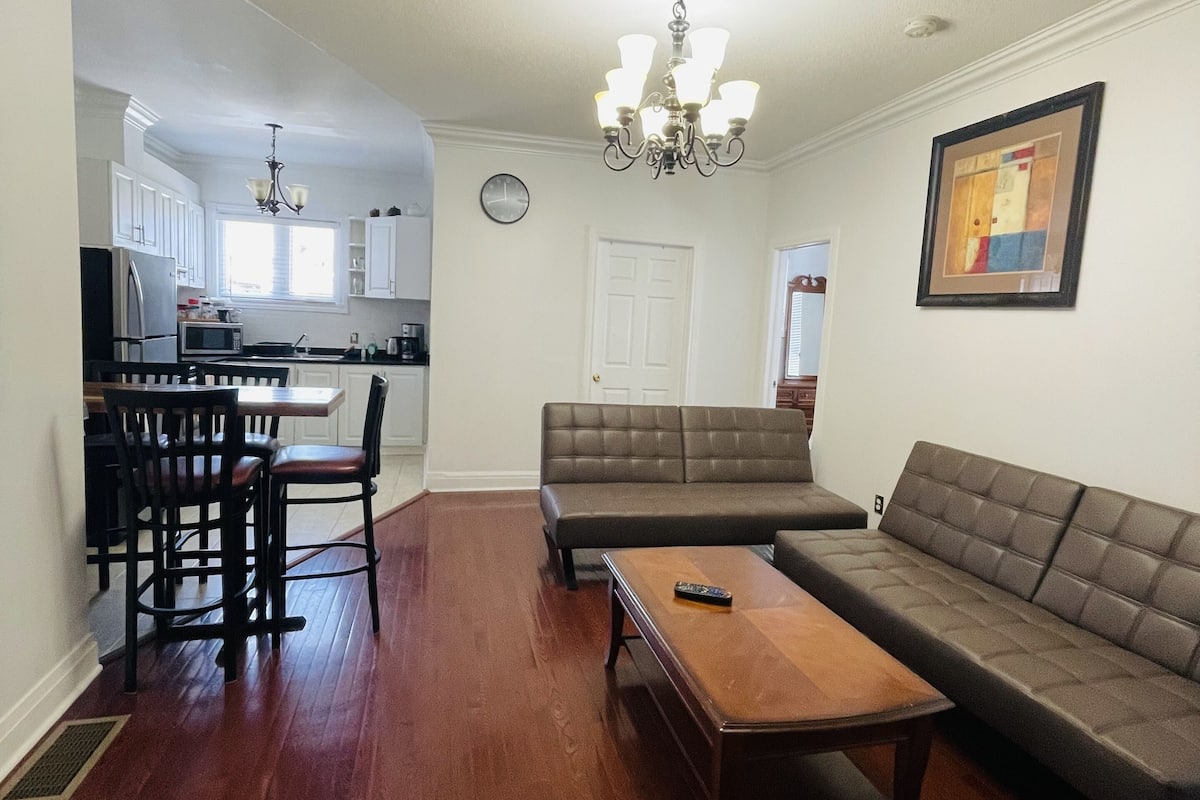 A living room with a sofa, a coffee table, and a dining area with chairs and a table.