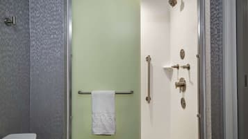 A bathroom with a shower, toilet, and towel rack.