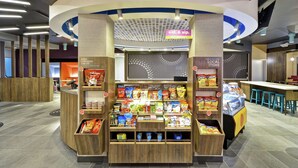 A snack kiosk with a variety of packaged snacks and a beverage dispenser. - Tru by Hilton Huber Heights (Dayton)