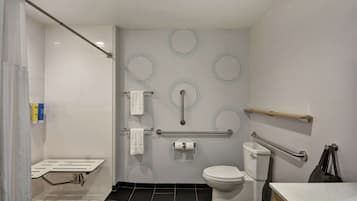 Un baño moderno con inodoro, bidé y barras de apoyo.