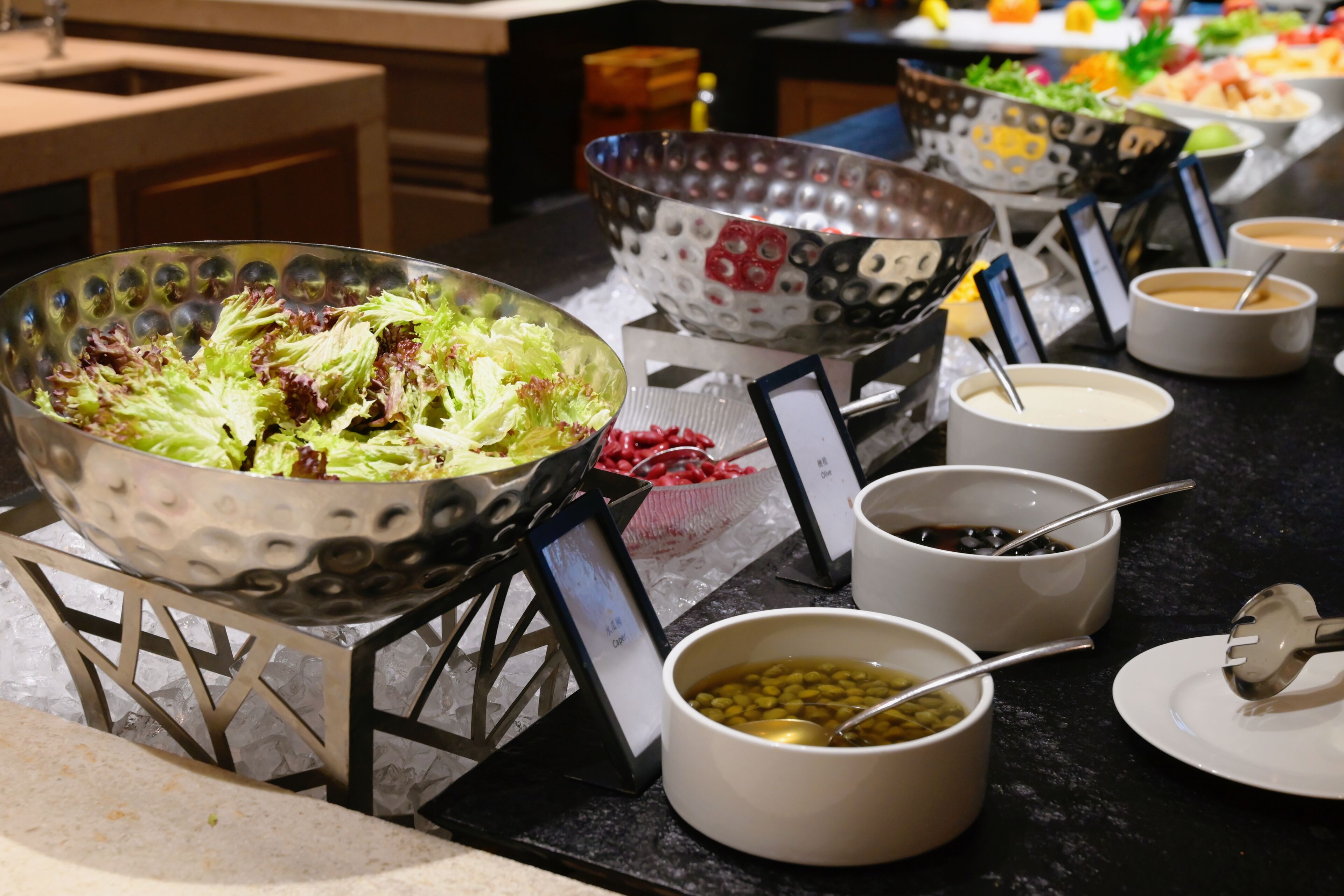 A buffet with various dishes and bowls of soup.