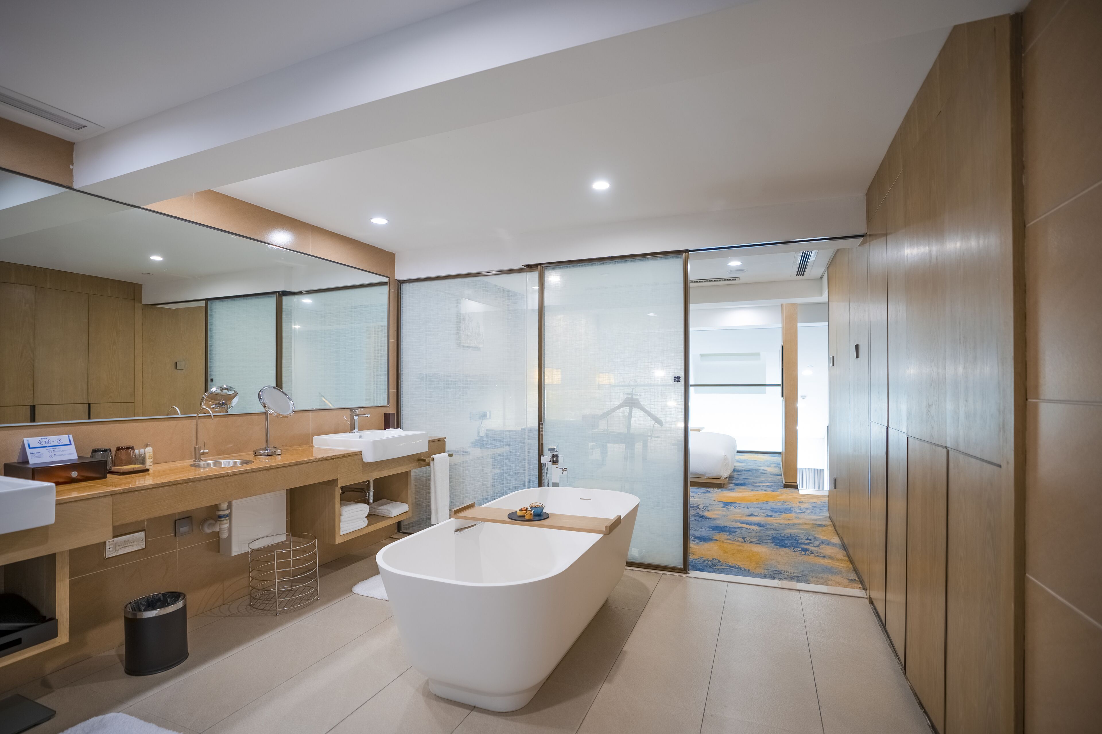 Un baño moderno con una bañera grande, dos lavamanos, un espejo y una zona de ducha.