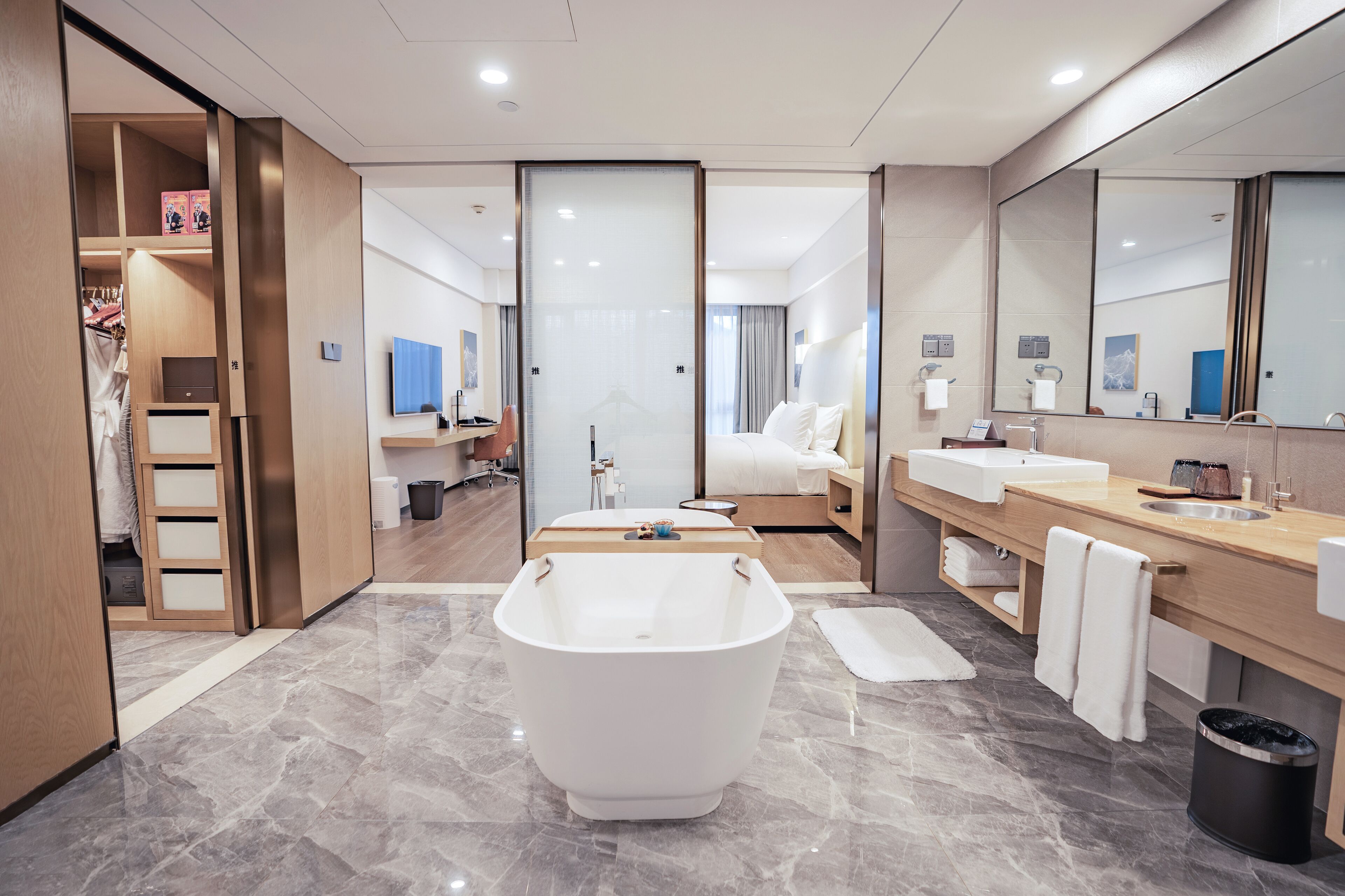 A modern bathroom with a freestanding bathtub, a vanity with a sink, and a large mirror.